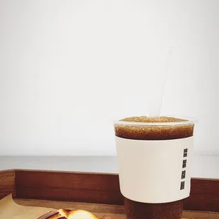 a cup of coffee and a half eaten pastry