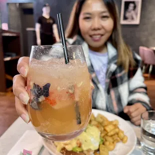 a woman holding up a drink