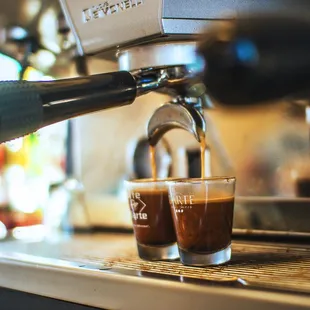 a shot of coffee being poured into a glass