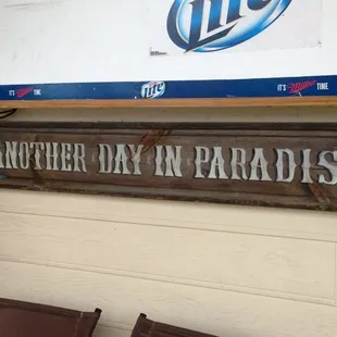 a sign that reads another day in paradise
