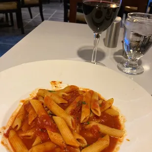 Vegan penne pasta and a glass of Pinot noir.