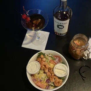 a bowl of salad and a bottle of wine