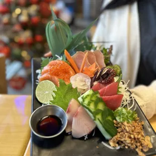 a woman holding a plate of sushi