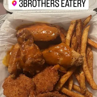 chicken wings and fries in a styrofoam container