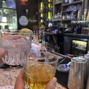 two people holding glasses of alcohol