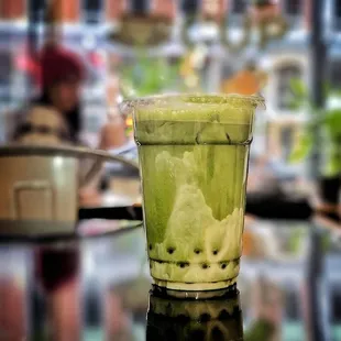 a cup of green tea on a table