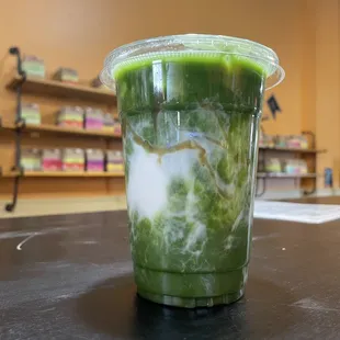 a green drink in a plastic cup