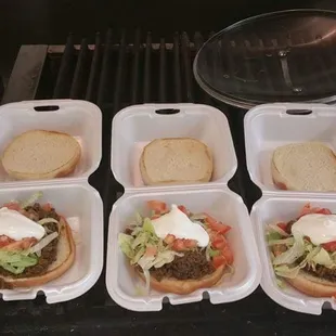 four hamburgers on a grill