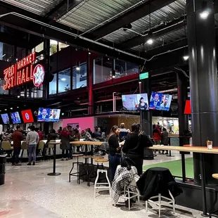 people sitting at tables and watching televisions