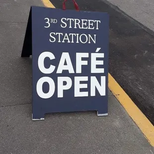 cafe open sign on sidewalk