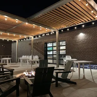 a patio with chairs and a fire pit