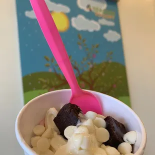 a hand holding a cup of yogurt