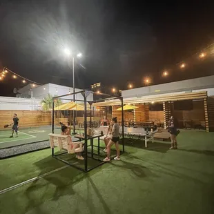 a group of people playing tennis at night