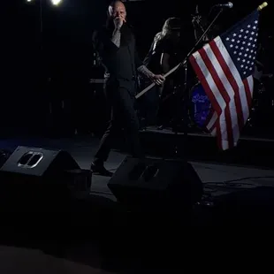 a man walking on stage with an american flag