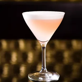 a pink cocktail in a coupe glass