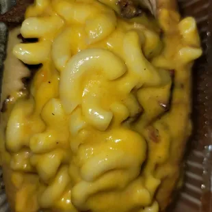 a hot dog covered in macaroni and cheese