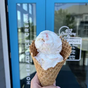 a hand holding a cone of ice cream
