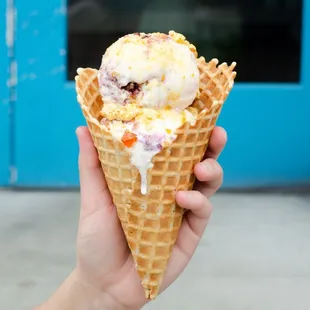 a hand holding a cone of ice cream