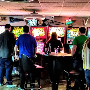 a group of people playing a game of pinball