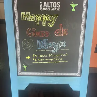 a chalkboard sign for a happy hour