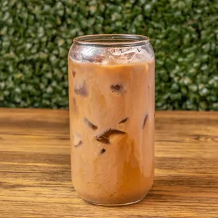 a glass of iced coffee on a wooden table