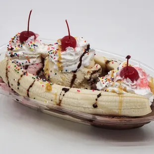 a banana split with whipped cream, chocolate syrup, and sprinkles