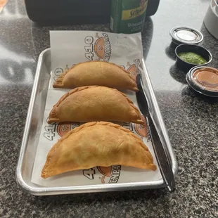 three empanadas on a tray