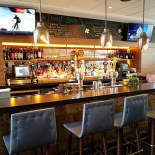 a bar with chairs and a television