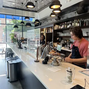 a woman behind the counter of a coffee shop