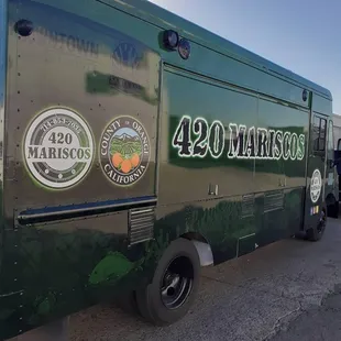 a green food truck parked in a parking lot