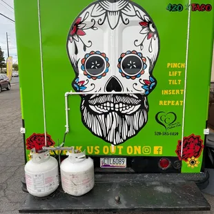a green truck with a skull painted on the side