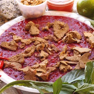 Tiet Canh aka duck blood topped with liver. Comes with herbs, lime, peanuts, sesame cracker &amp; ginger fish sauce.