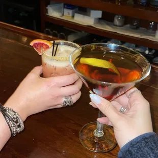 two people toasting at a bar