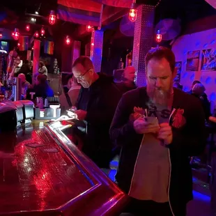 two men standing at a bar