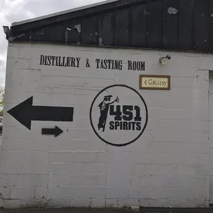 a white brick building with a black arrow pointing to the right