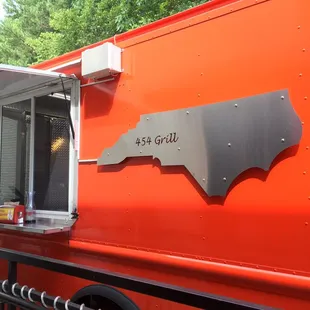 a red food truck parked on the side of the road