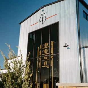 The West entrance and exterior view of 45th Parallel Distillery's restaurant, bar, and event space in New Richmond, Wisconsin.