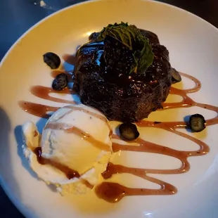 Chocolate cake with hot fudge, blueberries, blackberries and vanilla ice cream.
