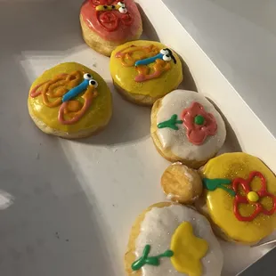 a variety of decorated donuts in a box