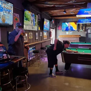 a man and a woman playing pool