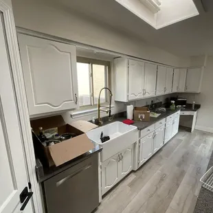 a kitchen with white cabinets and a skylight