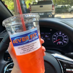 a hand holding a cup of juice