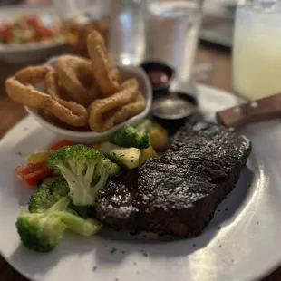 New York Strip with onion rings and steamed veggie mix.
