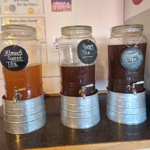 three beverage dispensers on a counter