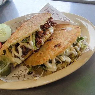 Hand-made corn gorditas stuffed with refried beans, cheese, shredded beef, sour cream, onion, cilantro and lettuce.