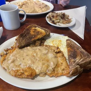 Chicken fried steak and in the background biscuits and gravy.