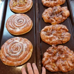 a person holding a tray of doughnuts