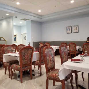 Dining area.  Open and friendly.   White table cloth and beautiful chairs.