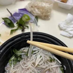 a bowl of noodles and chopsticks