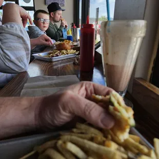 a man eating a hot dog and fries